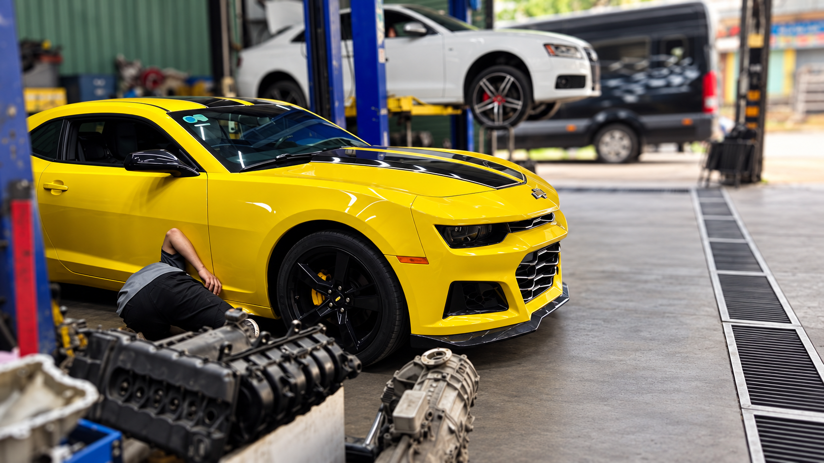 Chevrolet Camaro và xe trên cầu nâng trong khu sửa chữa.