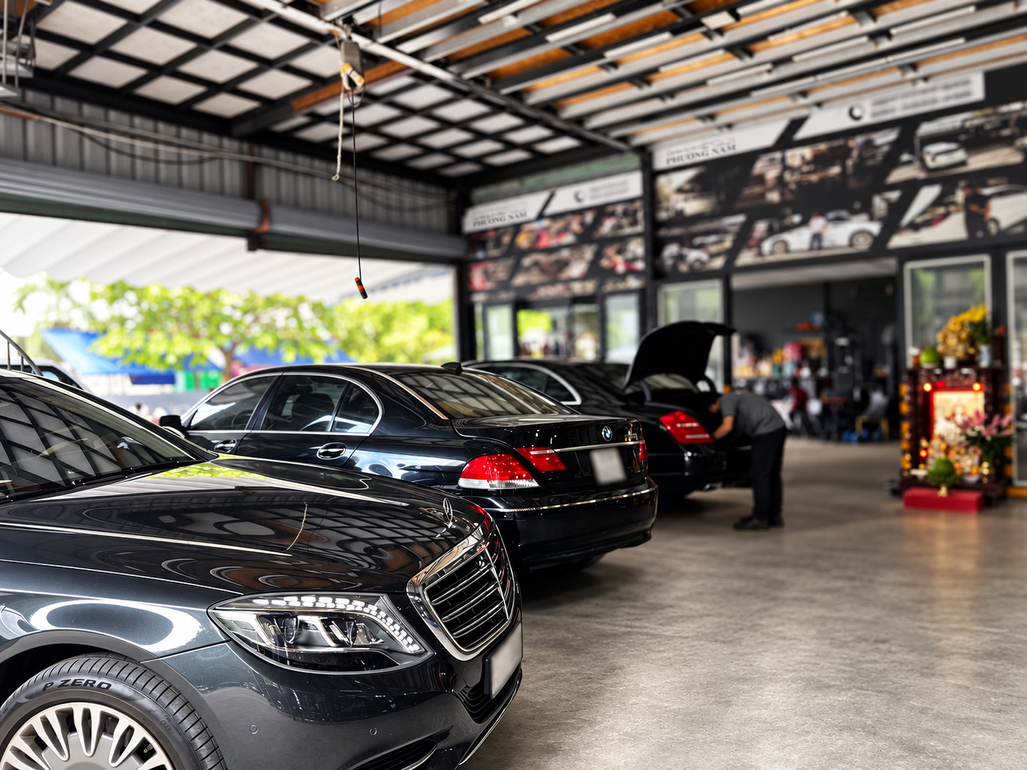 Kỹ thuật viên làm việc bên các xe trong xưởng.